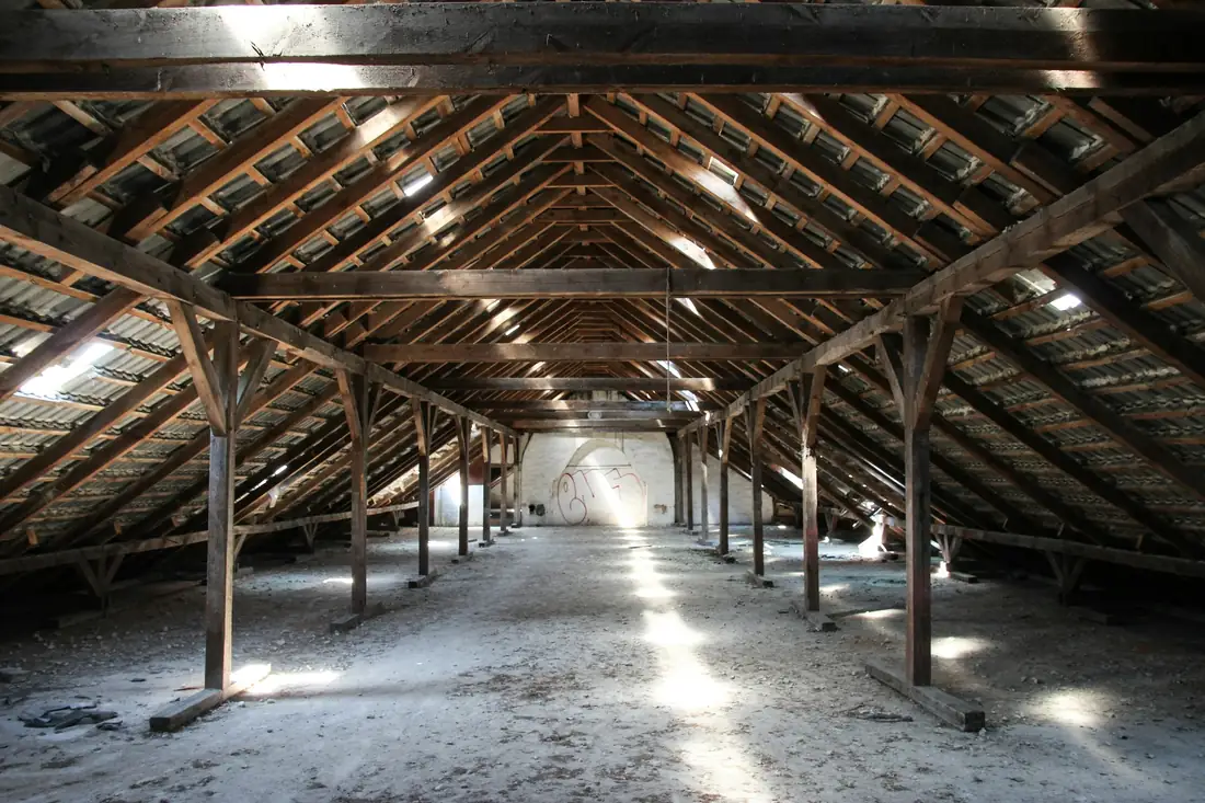 Grand grenier vide sous une charpente en bois apparente