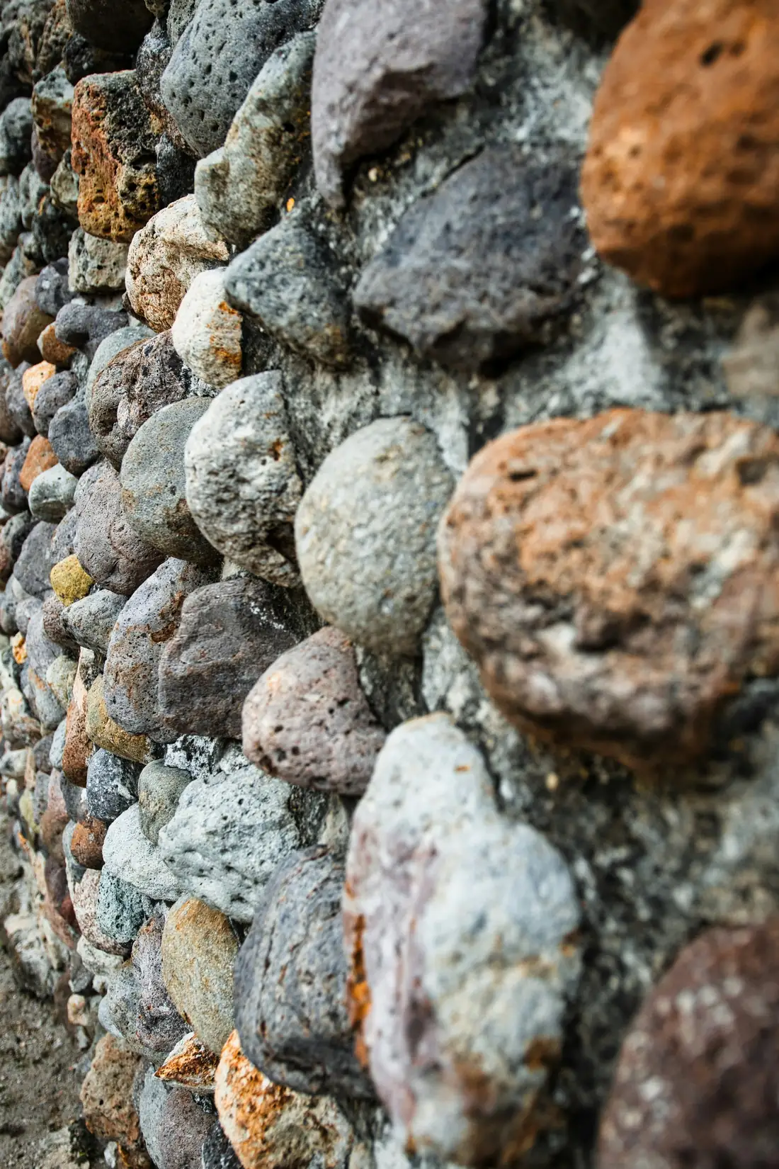 Galets arrondis pris dans le mortier d’un vieux mur, vus de près