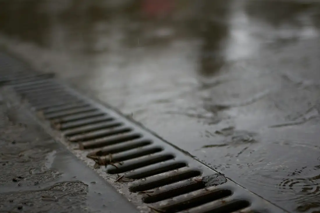 Grille d’évacuation des eaux sur une surface en béton mouillée par la pluie