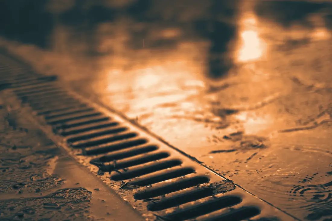 Grille d’évacuation des eaux sur une surface en béton mouillée par la pluie