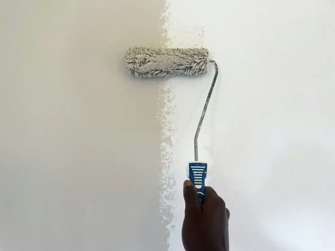 Rouleau qui applique une peinture blanche sur un mur