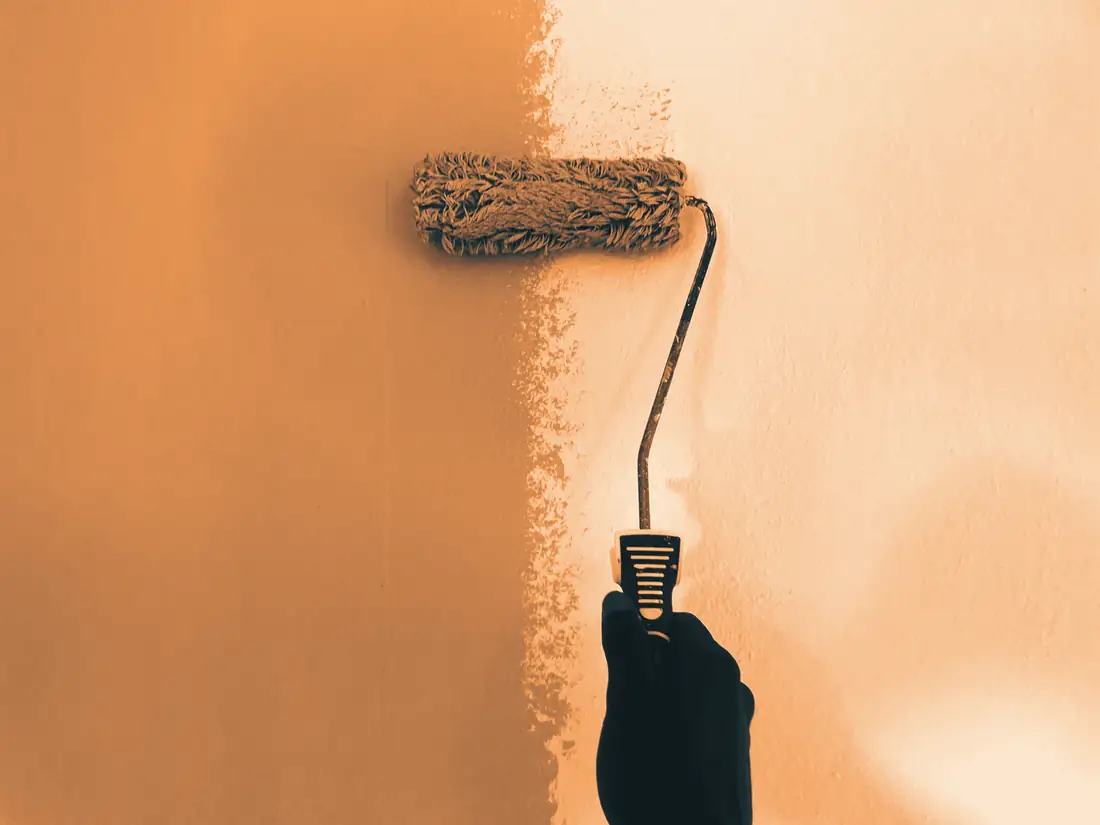 Rouleau qui applique une peinture blanche sur un mur